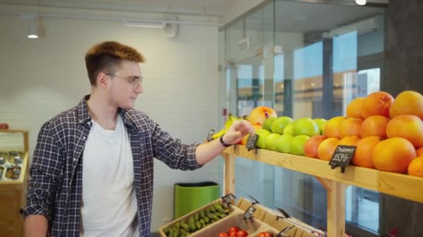 Jeune Client Masculin Choisit Des Agrumes Dans Magasin Aliments Biologiques — Video
