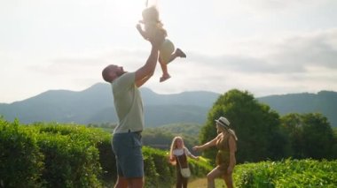 Doğada mutlu bir aile hafta sonu, aileleriyle birlikte yaz tatilinde yürüyen iki küçük kız, güneşli bir günde bahçede mutlu ve kaygısız insanlar.