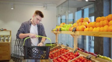 Vejetaryen marketten alışveriş yapıyor, akşam yemeği için sebze ve meyve alıyor, erkek alışverişçi modern süpermarketten domates, sağlıklı beslenme ve diyet seçiyor