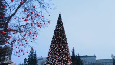 Novosibirsk, Rusya, 31.12.2020: Noel ağacı yakınlarındaki halk festivalleri ve kırmızı yıldız, balon ve çelenk şeklinde yeni yıl süslemeleri