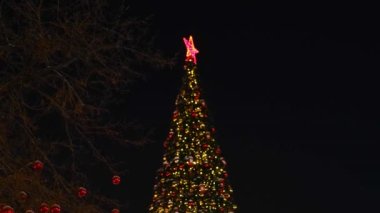 Yılbaşı çelenkleri ve Noel süsleri, kırmızı bir yıldız, sokakta balonlar.