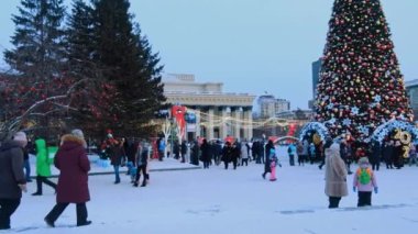 Novosibirsk, Rusya, 31.12.2020: Noel ağacı yakınlarındaki halk festivalleri ve kırmızı yıldız, balon ve çelenk şeklinde yeni yıl süslemeleri