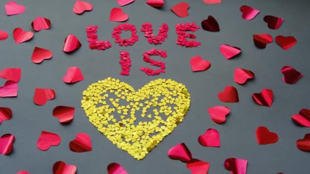 Aşk, kırmızı sevgililer gününde gri arka planda sarı bir kalptir. — Stok video