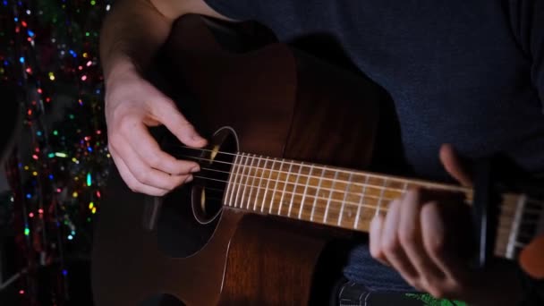 The guitarists hand plays a solo on an acoustic guitar. A man plucks the strings on a musical instrument — Stockvideo