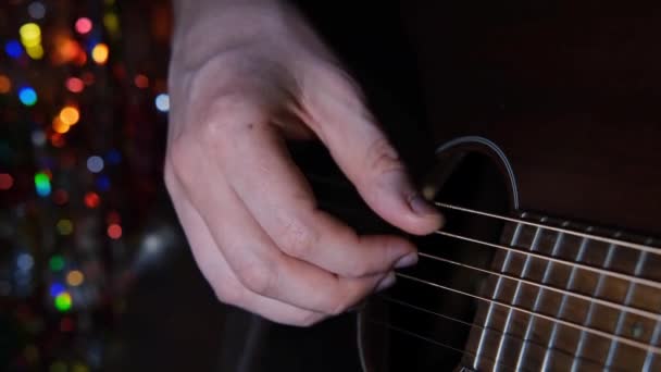 The guitarists hand plays a solo on an acoustic guitar. A man plucks the strings on a musical instrument — Vídeo de Stock