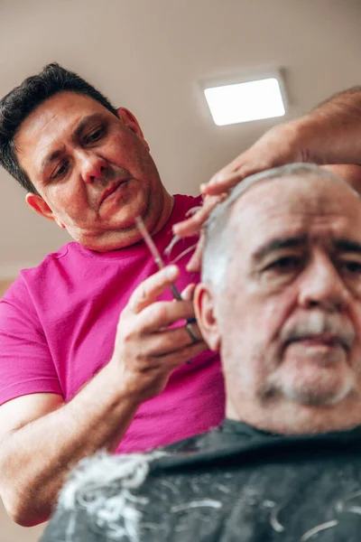old man getting a haircut