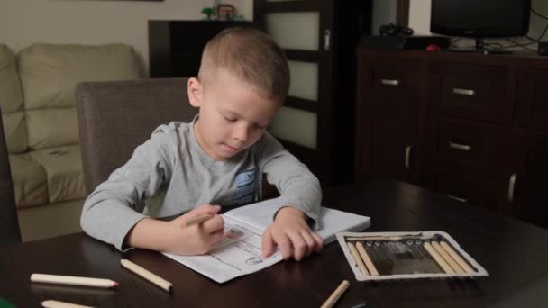 5-year-old boy doing homework with pencils — Stock Video