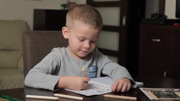 Niño de 5 años haciendo deberes con lápices — Vídeos de Stock