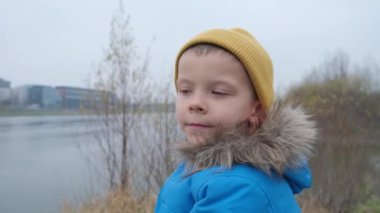 Nehir kenarındaki soğuk bir günde 5 yaşında bir çocuğun portresi.