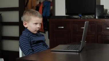 Beş yaşında bir çocuk bilgisayarda çizgi film izliyor.