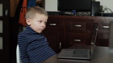 Beş yaşında bir çocuk bilgisayarda çizgi film izliyor.