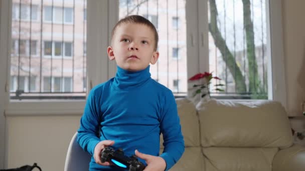 Un garçon de cinq ans joue une console — Video