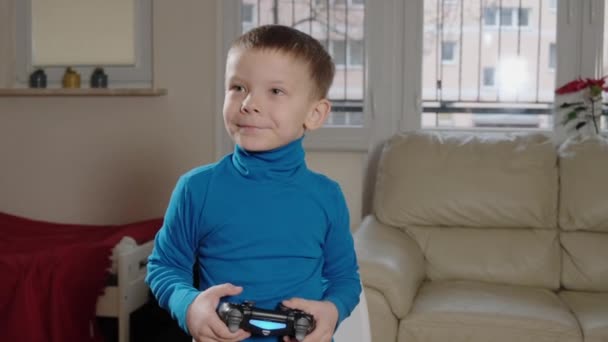 一个5岁的男孩在玩一个游戏机 — 图库视频影像