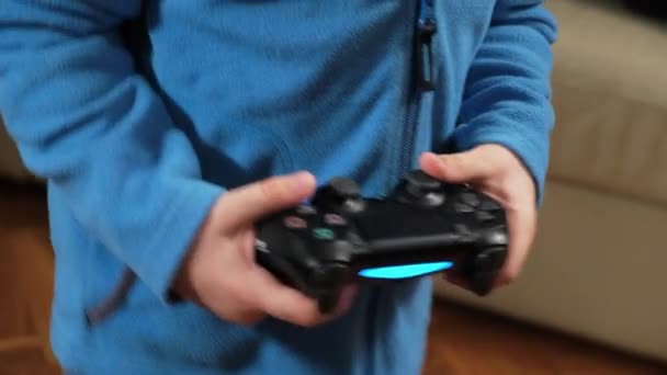 Mãos de um menino de cinco anos jogando um console de jogo com um joystick — Vídeo de Stock