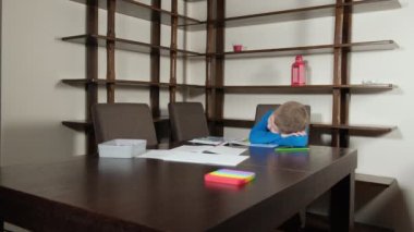 Çocuk ödevini yaparken uyuyakaldı.