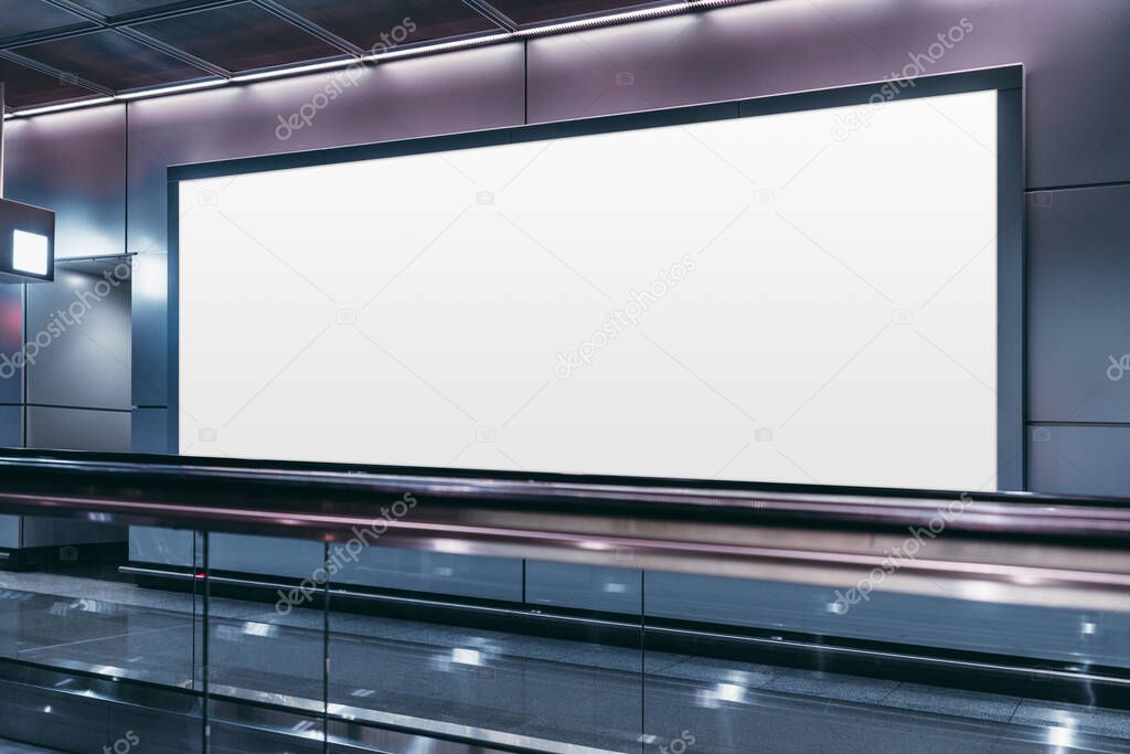 An empty billboard mockup next to a travelator in a modern airport arrival area; a white blank poster template indoors of a terminal of public transport building or shopping mall near a moving walkway