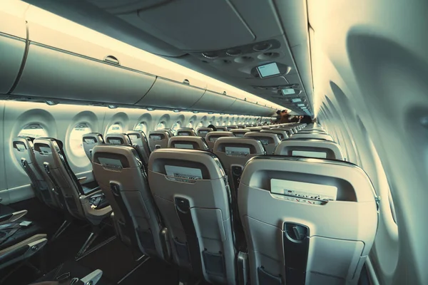 現代の航空機の中に座席の行を持つ長い空の飛行機のキャビンの広角ビュー 後部座席ポケットに紙の安全指示を置きます — ストック写真