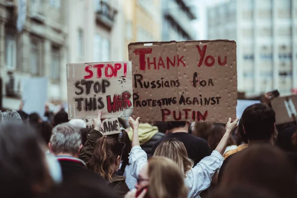 2022年2月27日 葡萄牙里斯本 有选择地关注一张标有 停止这场战争 字样的纸板海报 以及抗议普京和俄罗斯入侵乌克兰的人群 — 图库照片