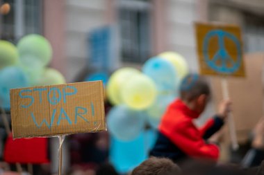 Lisbon, Portugal - February 27, 2022: crowd with paper placards, selective focus on a cardboard banner with 