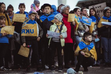 Lizbon, Portekiz - 20 Nisan 2022: Rusya 'nın işgaline karşı Mariupol şehrini kurtarma amaçlı protestolar sırasında etrafı Ukraynalı protestocularla çevrili bir grup çocuk