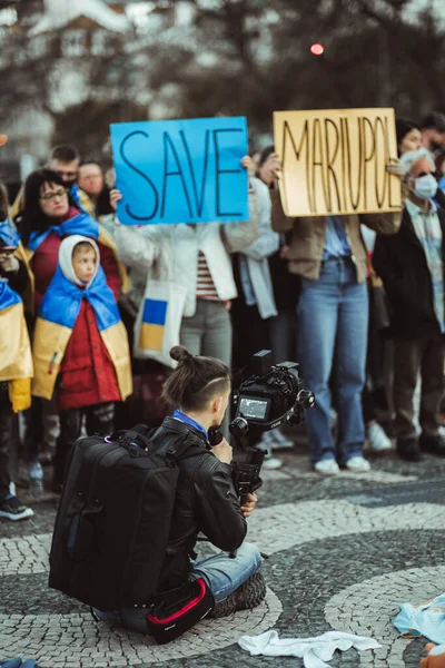 2022年4月20日 葡萄牙里斯本 一名摄影师坐在地上用相机稳定器拍摄一场抗议集会 这场集会是为了从俄罗斯手中拯救乌克兰城市马里乌波尔 — 图库照片