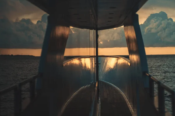 抽象视图 视野浅薄 有选择地聚焦于游艇木制地板的一部分 在窗玻璃的镜面上对称地反射出惊人的海洋落日 — 图库照片