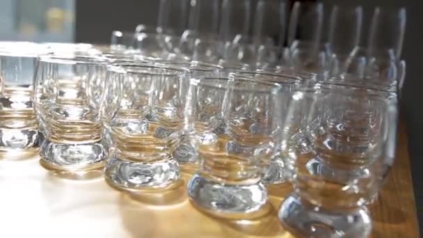 Uma mesa feita de copos e copos de diferentes tamanhos para diferentes bebidas. — Vídeo de Stock