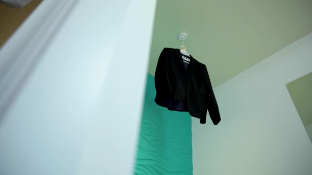 Mens suit on a hanger hanging in a stylish hotel room. — Stock Video