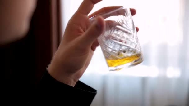 Fiatal férfi egy pohár whiskyt otthon — Stock videók