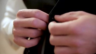 Adam yeleğini düğmede. Close. Son detay için mükemmel. Modern bir işadamı. Şık Klasik takım elbiseli yakışıklı bir genç adam moda vurdu. Mens güzellik, moda.
