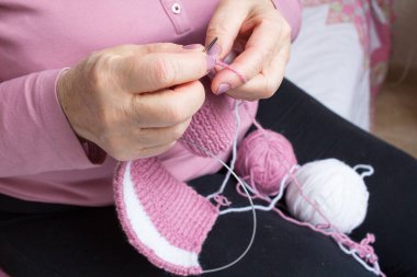 Yaşlı kadının örgü işleme süreci: kollar, dönüşler, iplik yakın