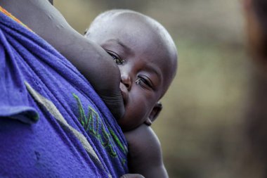 Omo Nehri Vadisi, Etiyopya, Kasım 2020, Mursi kabilesinde annesiyle birlikte bir bebek.