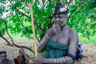 Omo Nehri Vadisi, Etiyopya - 29 Kasım 2020: Mursi kabilesi köyünde Yeşil Şapkalı Mutlu Afrikalı Adam 'ın portresi