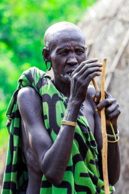 Omo Nehri Vadisi, Etiyopya - 29 Kasım 2020: Mursi kabilesinin yerel bir köyünde saçları kesilmiş, kulaklarında delikleri olan yaşlı bir Afrikalı kadının portresi