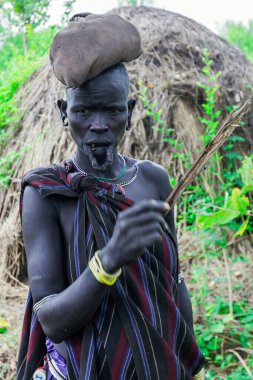 Omo Nehri Vadisi, Etiyopya - 29 Kasım 2020: Mursi kabilesi köyünde kafasında çuval olan geleneksel tahta tabak yerine büyük bir delikle yaşlı Afrikalı kadının portresi