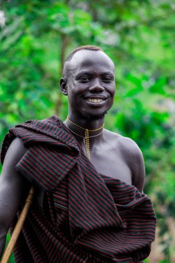Omo Nehri Vadisi, Etiyopya - 29 Kasım 2020: Mursi kabile köyünde geleneksel giysili Mutlu ve Tatmin Edilmiş Afrikalı Adam Portresi