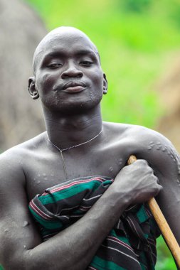 Omo Nehri Vadisi, Etiyopya - 29 Kasım 2020: Mursi kabile köyünde geleneksel giysili Mutlu ve Tatmin Edilmiş Afrikalı Adam Portresi