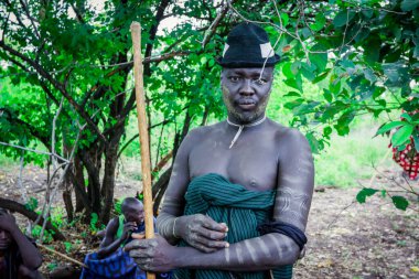 Omo Nehri Vadisi, Etiyopya - 29 Kasım 2020: Mursi kabilesi köyünde Yeşil Şapkalı Mutlu Afrikalı Adam 'ın portresi