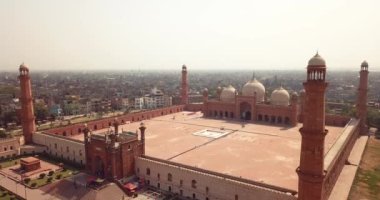 4K Aerial Footage to the Badshahi Mosque main courtyard with the Minarets in carved red sandstone with marble inlay, Pakistan