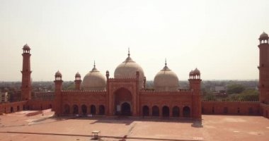 4K Hava Görüntüsü: Baadshahi Camii 'nin ana avlusu. Pakistan' ın mermer işlemeli kırmızı kumtaşında Minaretler var.