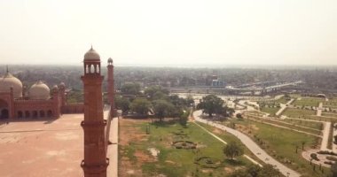 4K Hava Görüntüsü: Baadshahi Camii 'nin ana avlusu. Pakistan' ın mermer işlemeli kırmızı kumtaşında Minaretler var.