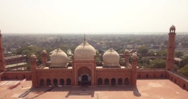 4K Hava Görüntüsü: Baadshahi Camii 'nin ana avlusu. Pakistan' ın mermer işlemeli kırmızı kumtaşında Minaretler var.