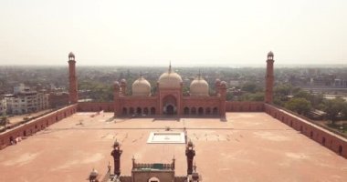 4K Aerial Footage to the Badshahi Mosque main courtyard with the Minarets in carved red sandstone with marble inlay, Pakistan