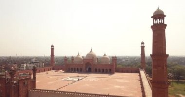 4K Hava Görüntüsü: Baadshahi Camii 'nin ana avlusu. Pakistan' ın mermer işlemeli kırmızı kumtaşında Minaretler var.