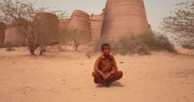 4K Aerial Footage View to the Young Boy near Derawar Fortress in Cholistan Desert, Pakistan