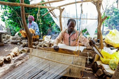 Konso, Etiyopya - 30 Kasım 2020: Afrikalı Konso Adam Yerel Kabile Köyü 'nde Tahta Tekerlek üzerinde elleriyle dönüyor