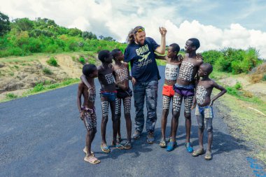 Benna Kabilesi yakınlarında poz veren Beyaz Büyük Adam Turist Geleneksel Vücut Boyama ile Genç Oğlanlar
