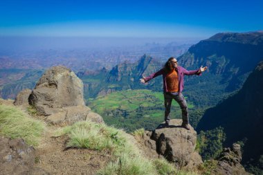 White Man Tourist posing on the Green Valley of Simien Mountains near Gondar, Northern Ethiopia