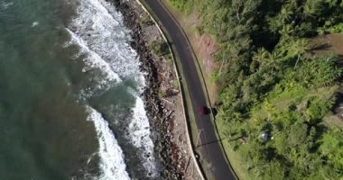 4K Aerial Footage of the Wild coast of Dominica Island and the road with passing cars, Caribbean Sea