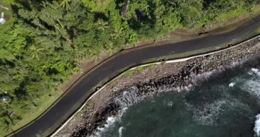 4K Aerial Footage of the Wild coast of Dominica Island and the road with passing cars, Caribbean Sea